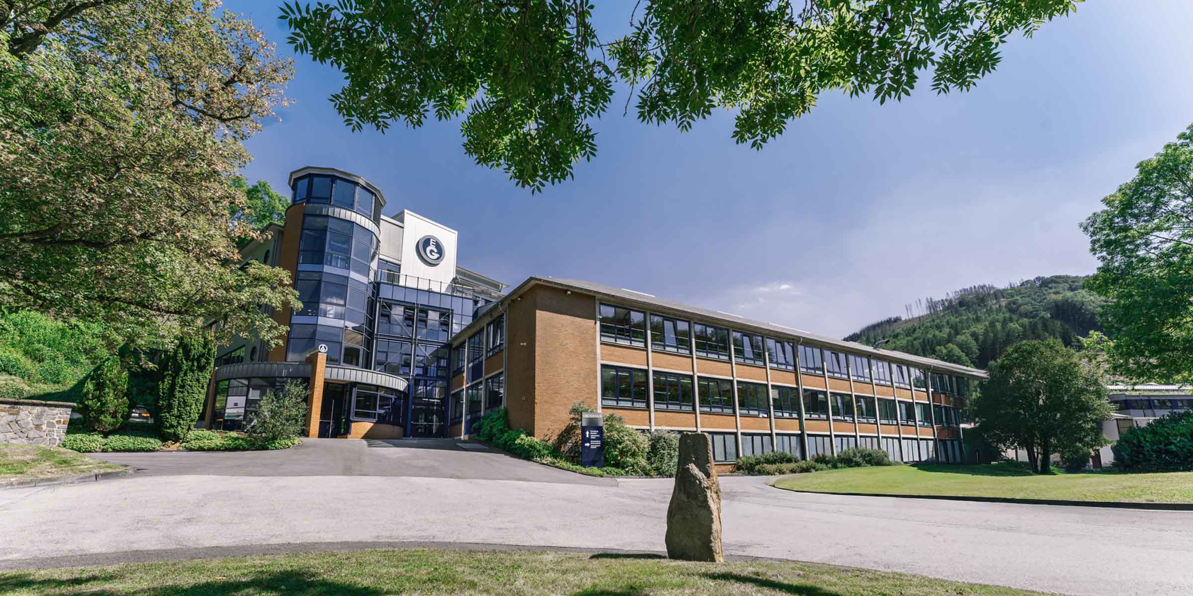 AUssenansicht des GROSSHAUS-Standortes am Bonzelerhammer mit der Sicht auf Verwaltungsgebäude und einem Produktionsgebäude aus Backsteinen